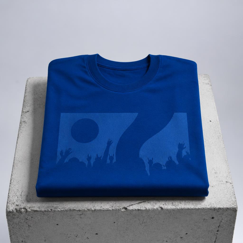 Folded cobalt event T-shirt on a concrete plinth